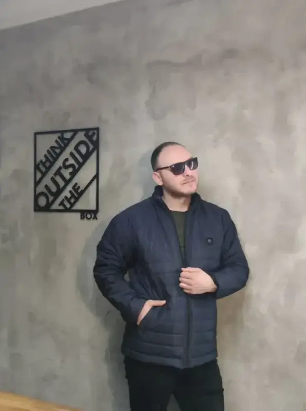 Person wearing a navy blue puffer jacket and sunglasses.