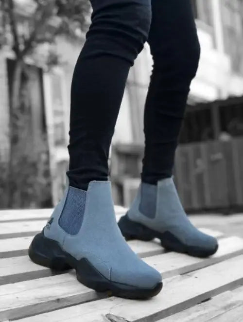 Light blue Chelsea boots with black chunky soles and elastic side panels.