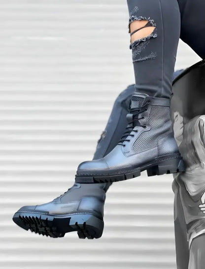 Black combat boots with chunky treaded soles and mesh detailing.