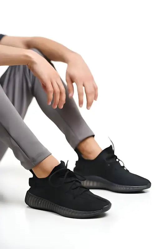 Black athletic sneakers with mesh uppers and dark soles.