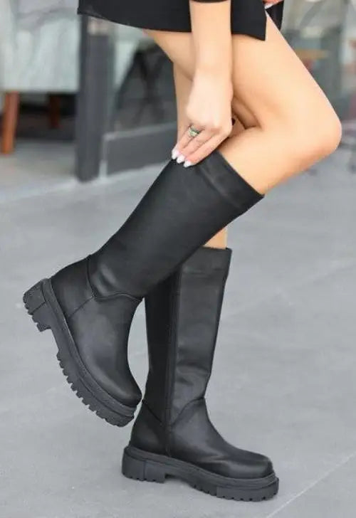 Black leather knee-high platform boots with chunky treaded soles.