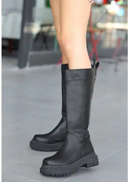 Black leather knee-high platform combat boots.