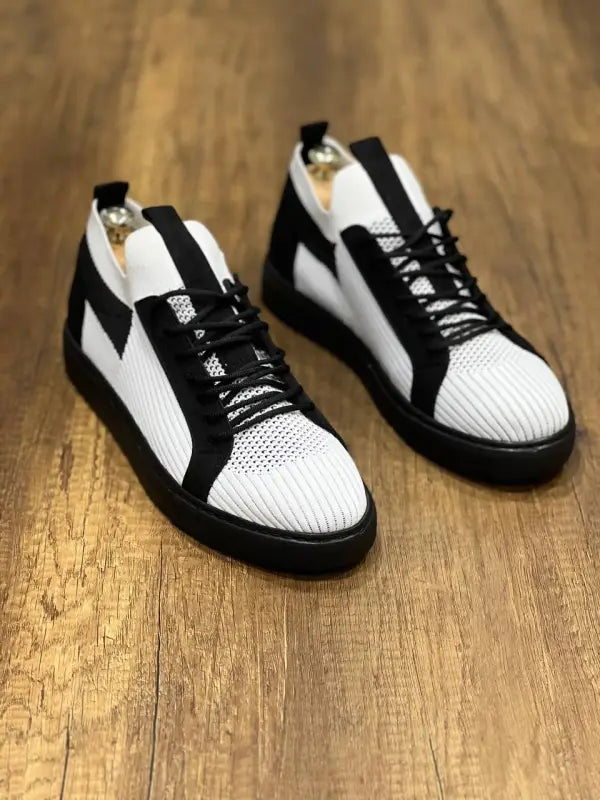 Black and white athletic sneakers with perforated mesh uppers and rubber soles.