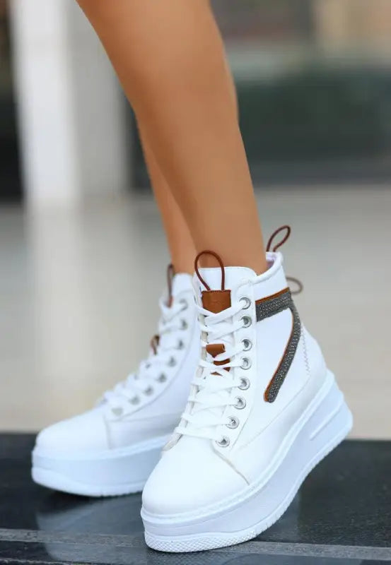 White high-top sneaker with brown leather accents and side zipper detail.