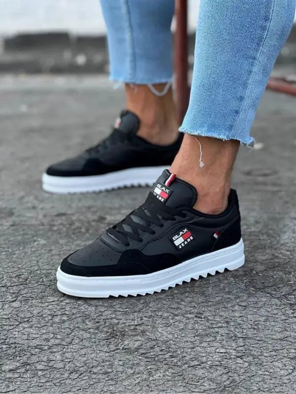 Black sneakers with white platform soles and a small red logo detail.