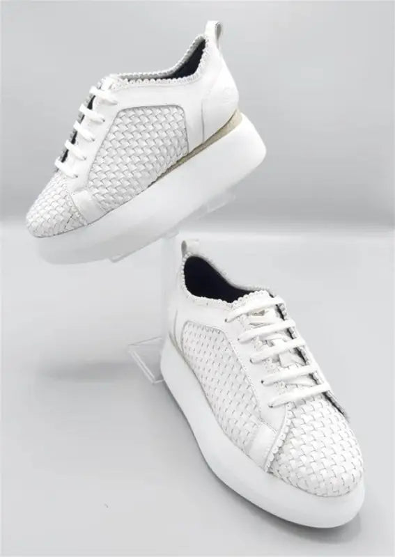 White textured sneakers with platform soles and laces.