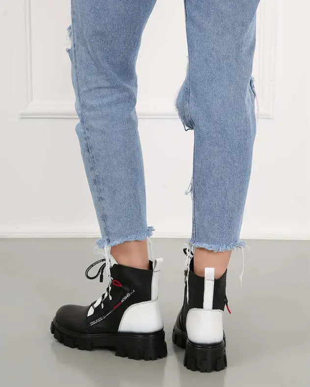 Black and white chunky combat boots with platform soles and laces.