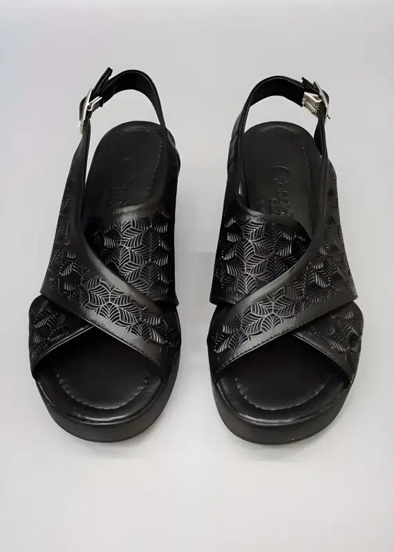 Black leather sandals with a crossover strap design and embossed pattern.