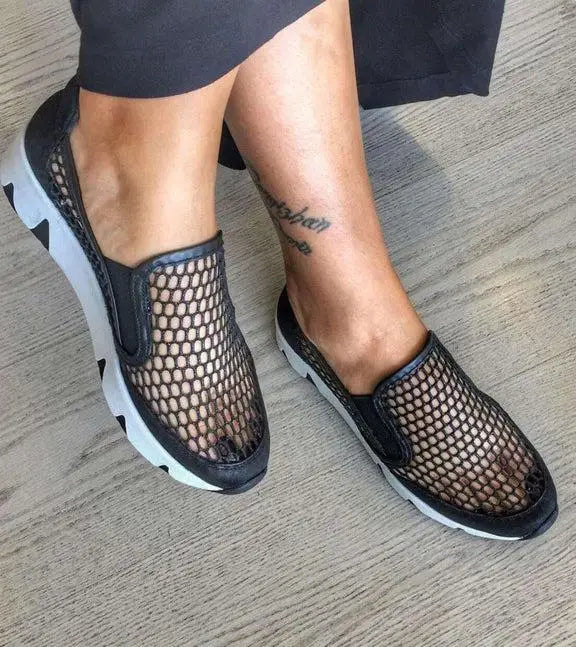 Black mesh slip-on shoes with white soles and a honeycomb pattern design.