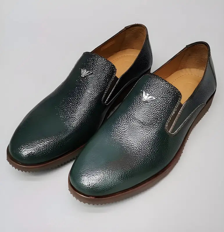 Pair of dark green textured leather loafers with slip-on design.