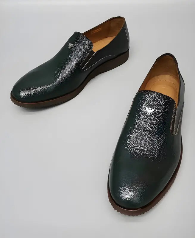 Dark green leather slip-on dress shoes with textured detailing.