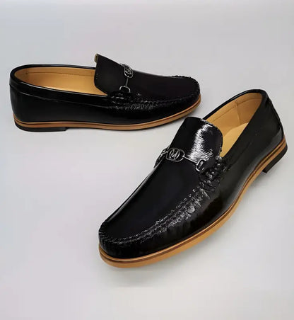 Black leather loafers with metal buckle detail and moccasin stitching.