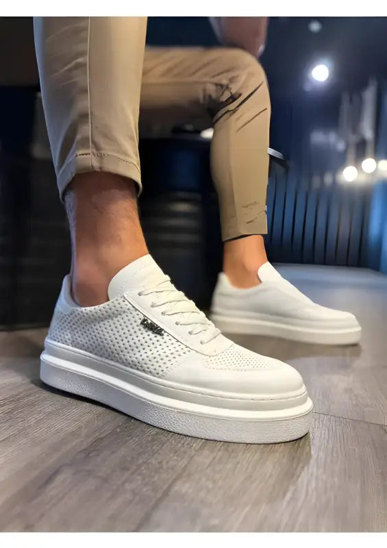 White perforated leather sneakers with a thick platform sole.