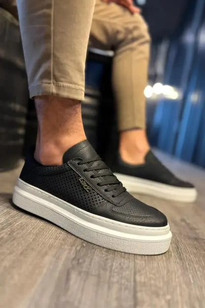 Black leather sneaker with perforated detailing and a white platform sole.