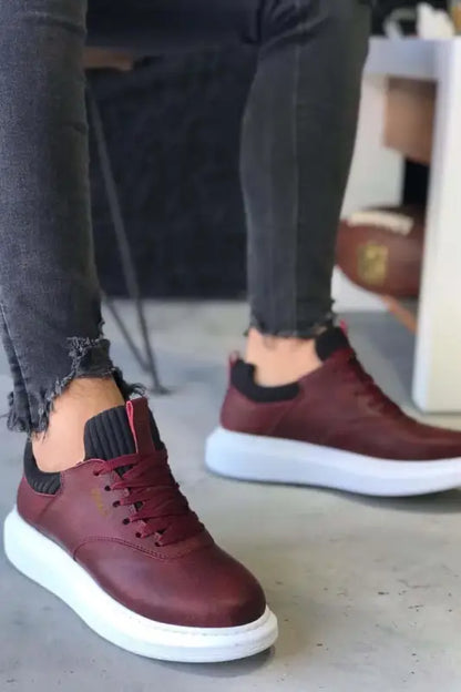 Burgundy leather sneakers with white soles and black ankle socks.