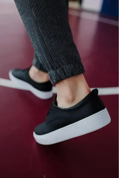 Black slip-on sneaker with a white platform sole.