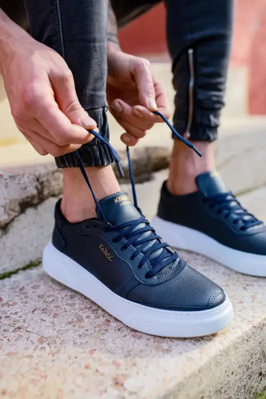 Navy blue leather sneakers with white platform soles and matching laces.