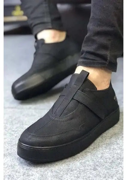 Black leather slip-on sneakers with a velcro strap across the top.