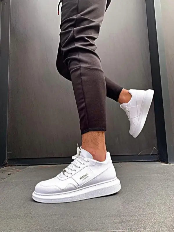 White leather sneakers with thick platform soles and laces.