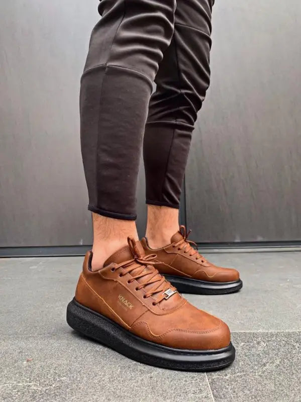 Brown leather sneakers with thick black platform soles and laces.