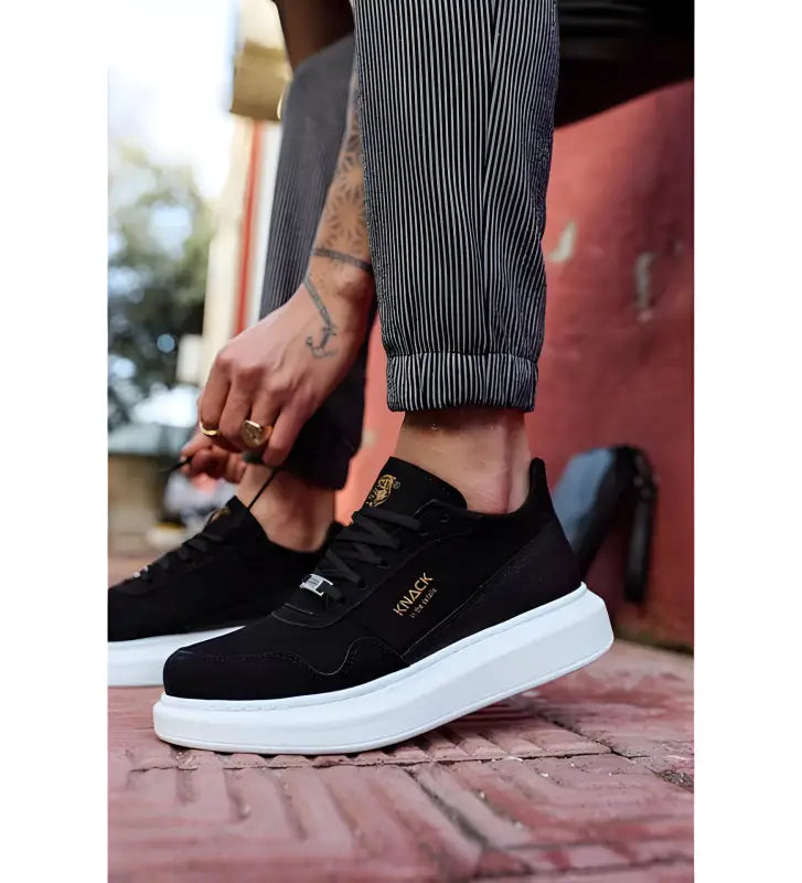 Black suede sneaker with white platform sole.