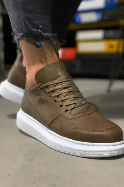 Brown leather sneaker with white sole and tan laces.