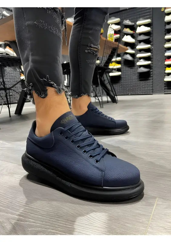 Navy blue sneakers with thick black soles and matching laces.