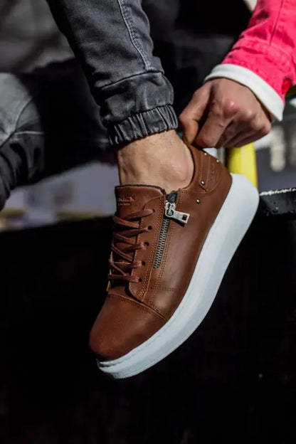 Brown leather sneaker with side zipper and white platform sole.