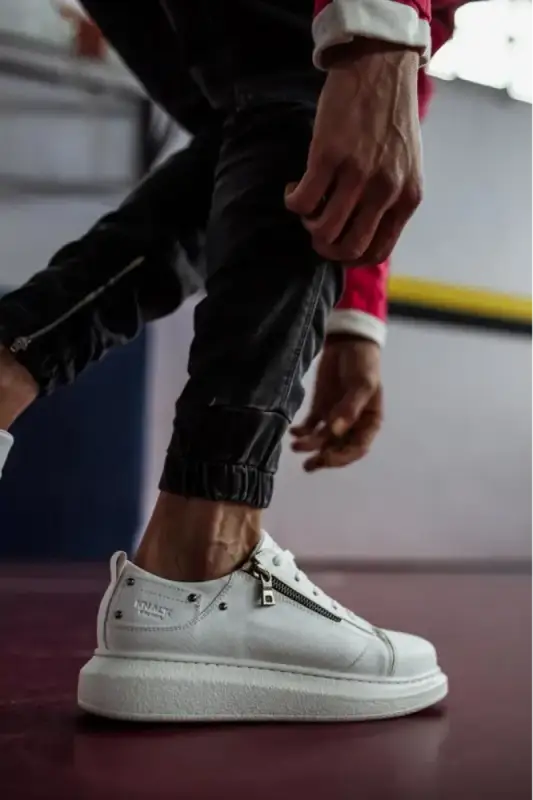 White Alexander McQueen sneaker with silver studs and a thick sole.