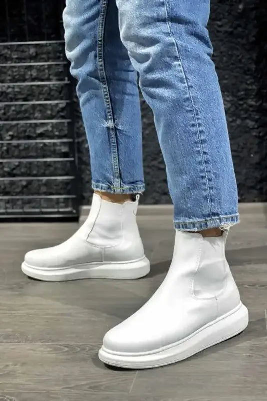 White ankle boots with chunky soles paired with light-wash jeans.