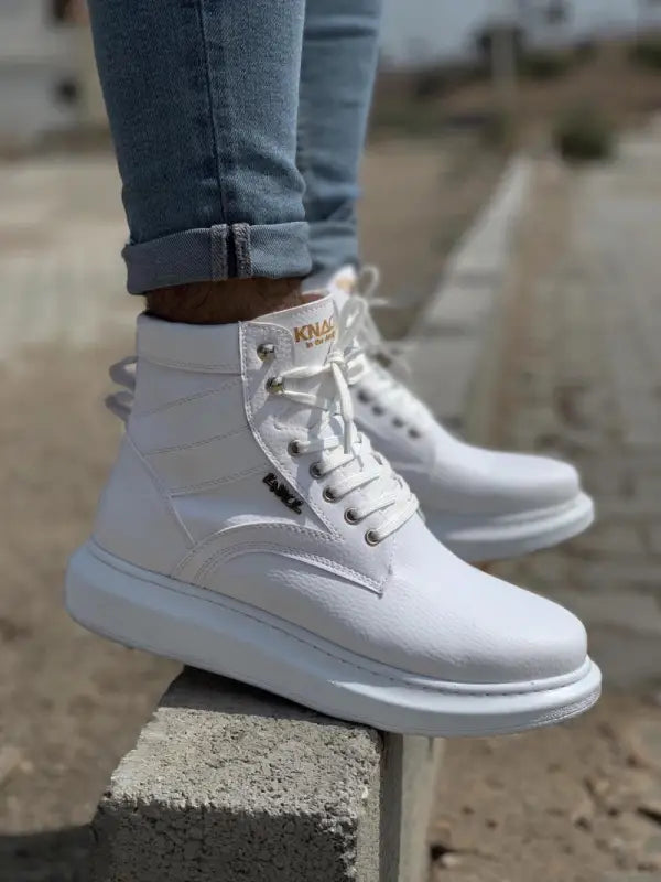 White high-top sneakers with thick soles and laces.