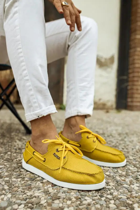 Bright yellow leather boat shoes with white soles and yellow laces.