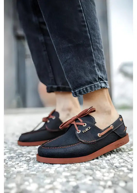 Navy blue boat shoes with brown leather accents and red rubber soles.