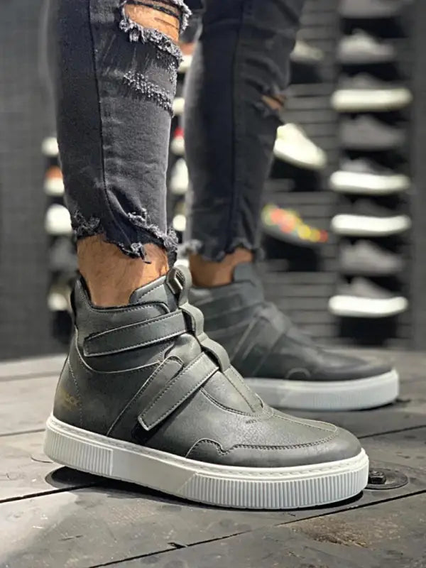 Grey high-top sneaker with velcro straps and a white platform sole.