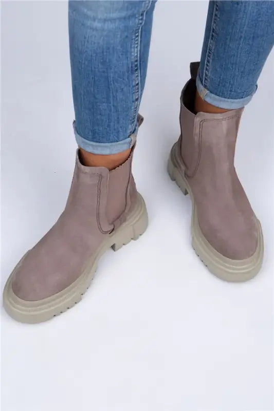 Taupe chelsea boots with chunky rubber soles and elastic side panels.