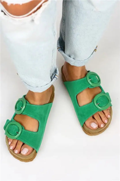 Bright green sandals with decorative buckles and a cork-style footbed.