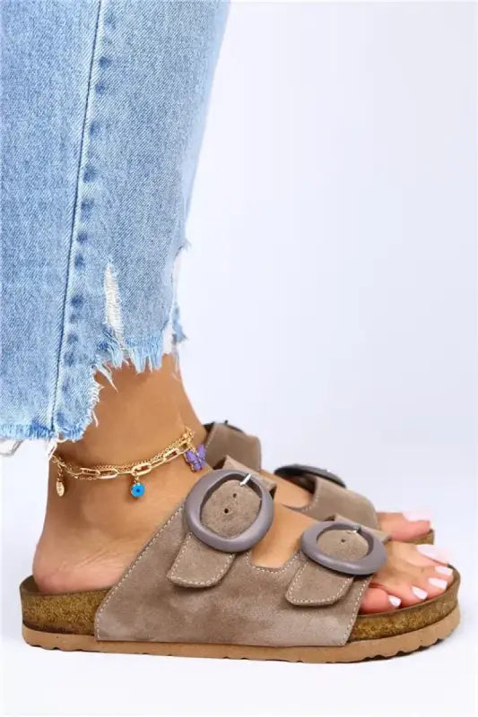 Taupe double-buckle cork footbed sandals with a gold ankle chain accessory.