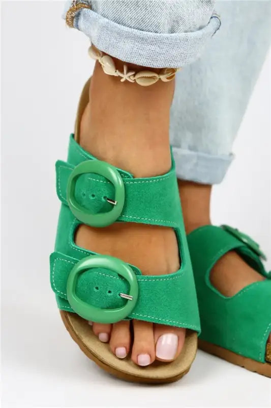 Bright green suede sandals with two oversized buckle straps.