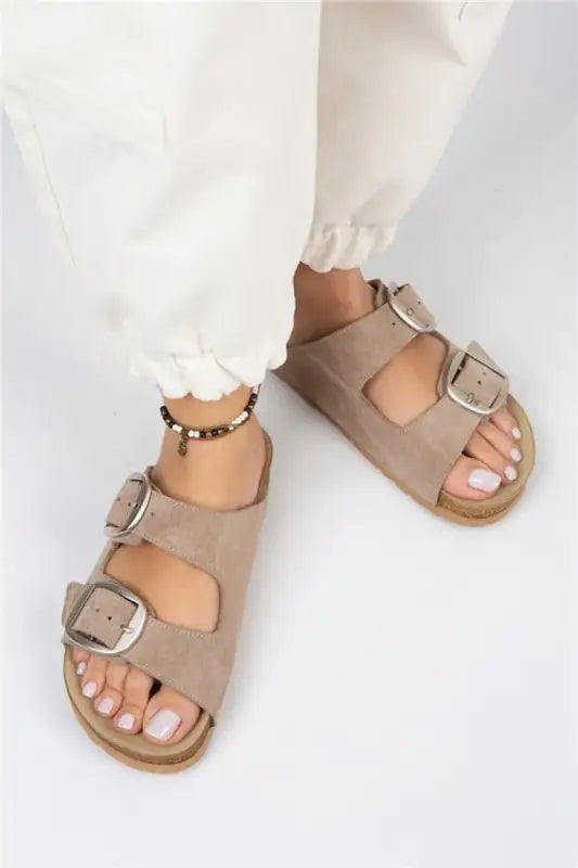 Beige double-buckle sandals with a cork-style footbed.