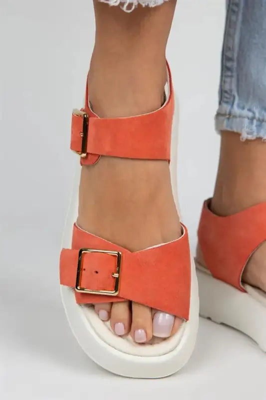 Coral-colored platform sandal with double buckle straps and a white sole.