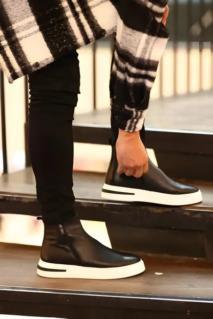 Black leather slip-on sneakers with white platform soles.