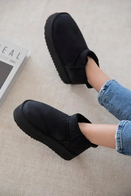 Black platform slip-on slippers with a thick cushioned sole.