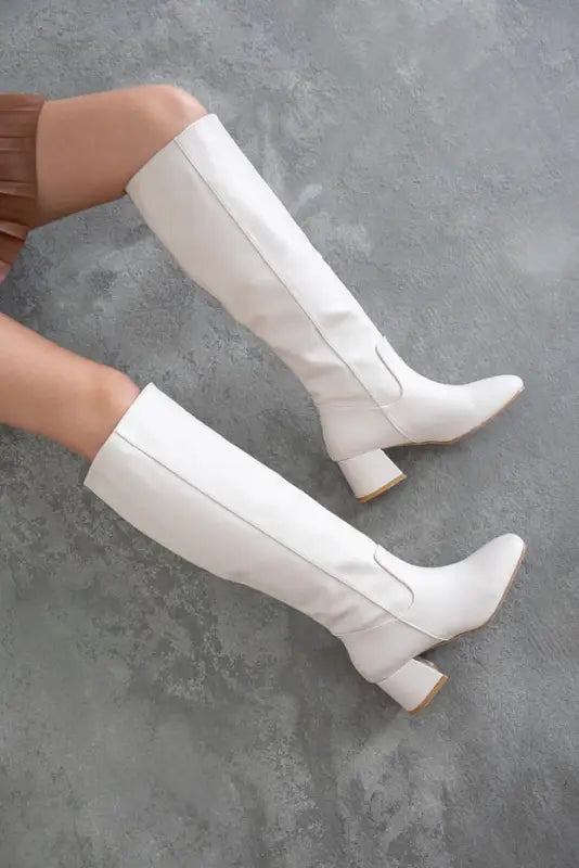 White knee-high boots with chunky heels.