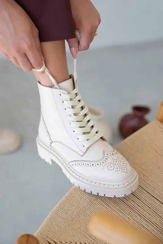 White leather combat boot with brogue detailing and chunky platform sole.