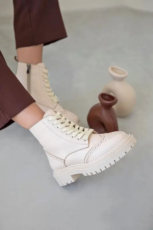 White leather combat boot with chunky platform sole and laces.