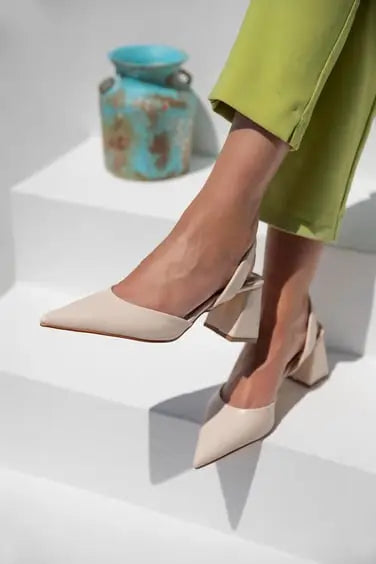 Beige pointed-toe block heel pumps with a modern silhouette.