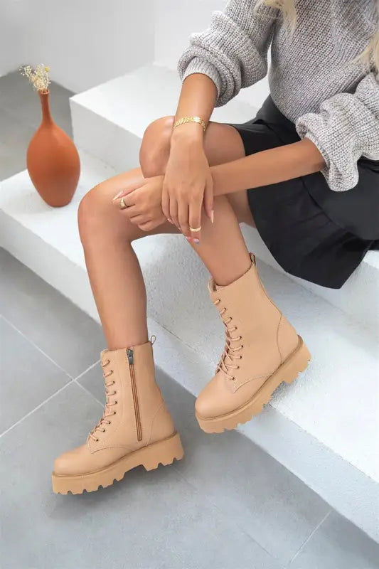 Beige combat boots with chunky soles and lace-up design.