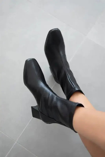 Black leather ankle boots with chunky heels.