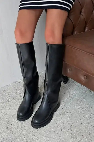 Pair of black leather knee-high boots with flat soles.