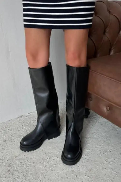 Pair of black leather knee-high boots with chunky soles.